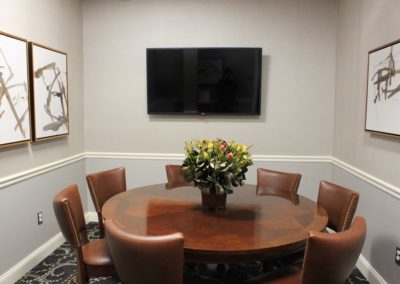 Eagle Room with TV and floral centerpiece on round table.