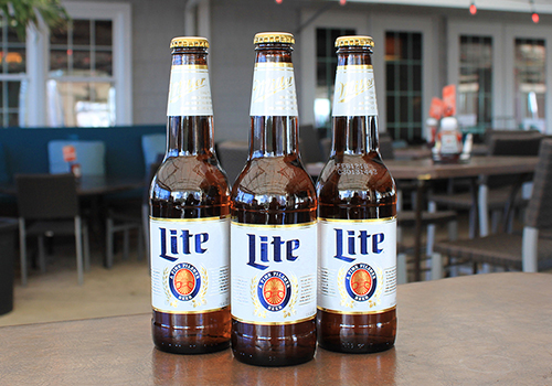 Three Miller Lite Beer bottles on table.